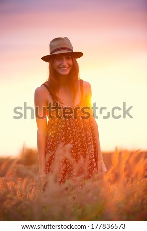 Beautiful happy woman in golden field at sunset, Carefree healthy lifestyle, Vibrant color, Backlit warm tones