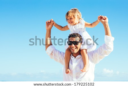 Healthy father and daughter playing together at the beach