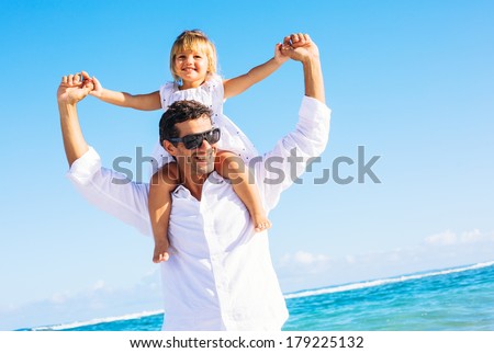 Healthy father and daughter playing together at the beach