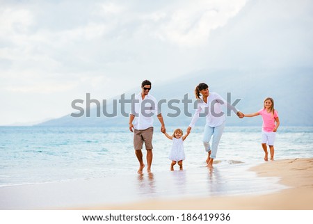 Happy young family walking on the beach at sunset. Happy Family Lifestyle