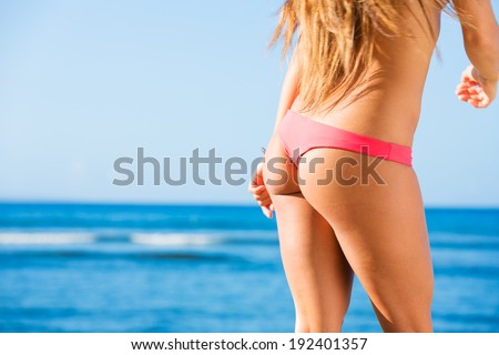 Sexy back of a beautiful woman on tropical beach in small sexy bikini