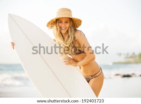 Beautiful carefree happy surfer girl on the beach at sunset. Beach culture lifestyle concept.