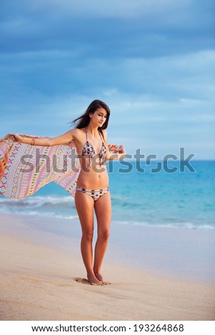 Beautiful Young Woman With Scarf on the Beach at Sunset. Travel and Vacation Concept. Fashion Lifestyle.