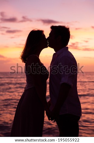 Silhouette of Romantic couple kissing at sunset on the beach