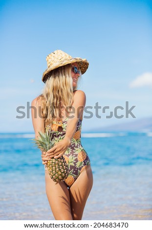 Fun retro beach fashion concept. Woman in pineapple bathing suit and sun hat at the beach