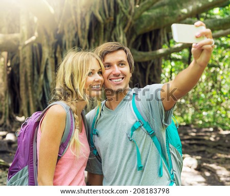 Couple having fun together outdoors. Taking self portrait with camera phone on hike.