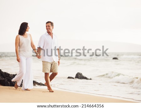 Mature Retired Couple Enjoying Sunset Walk on the Beach
