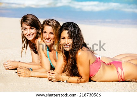 Beautiful Girls in Bikinis Sunbathing on the Beach. Summer fun lifestyle.