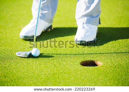 Man Putting Golf Ball into the Hole, Close up detail Shot