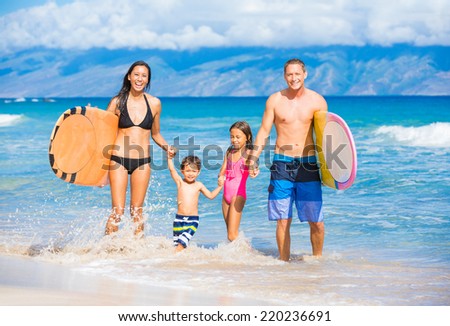 Happy Family with Surfboards on the Beach in Hawaii