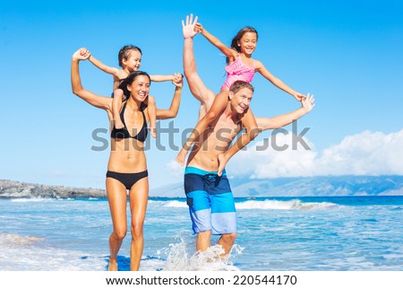 Happy Mixed Race Family of Four Playing and Having Fun on the Beach. Tropical Beach Family Vacation.