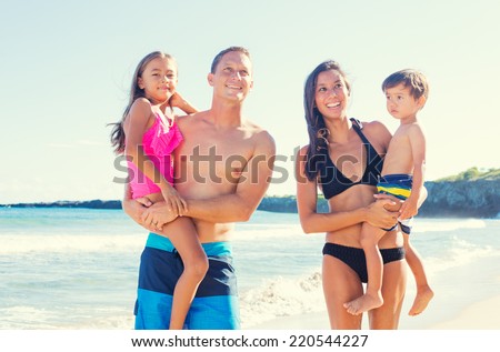 Happy Mixed Race Family of Four on Sunny Beach. Tropical Beach Family Vacation.