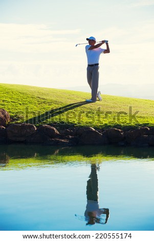 Silhouette of Man Playing Golf on Beautiful Course, Reflection in Water