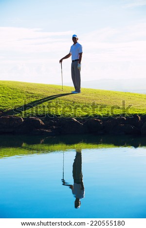 Silhouette of Man Playing Golf on Beautiful Course, Reflection in Water