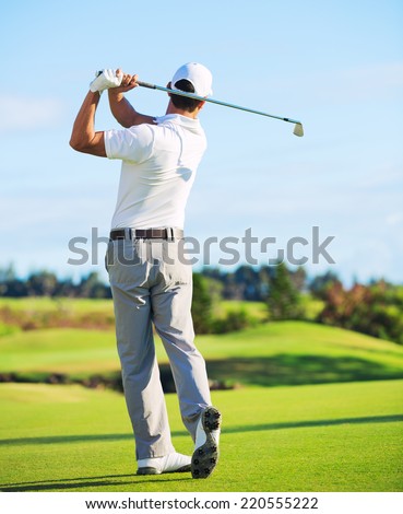 Man Playing Golf on Beautiful Sunny Green Golf Course. Hitting Golf Ball down the Fairway.