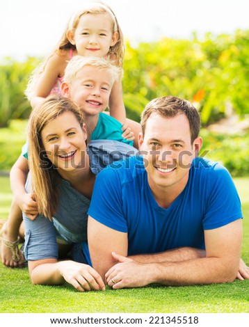 Portrait of Happy Family of Four Outside. Parents and Two Young Children