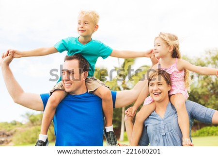 Portrait of Happy Family of Four Outside Playing