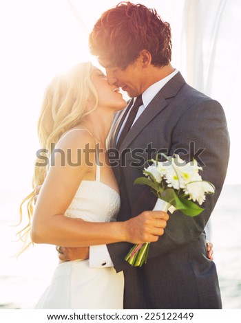 Wedding, Beautiful Romantic Bride and Groom Kissing and Embracing at Sunset
