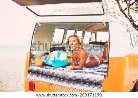 Beach Lifestyle, Beautiful Surfer Girl Relaxing in Classic Vintage Surf Van on the Beach at Sunset