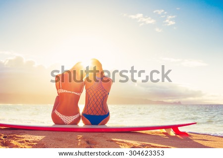 Surfer Girls on the Beach At Sunset. Summer Outdoor Lifestyle. Best Friends Hanging Out on the Beach.