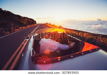 Driving into the Sunset. Romantic Young Couple Enjoying Sunset Drive in Classic Vintage Sports Car