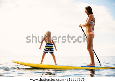 Mother and Son Stand Up Paddling Together Having Fun in the Ocean