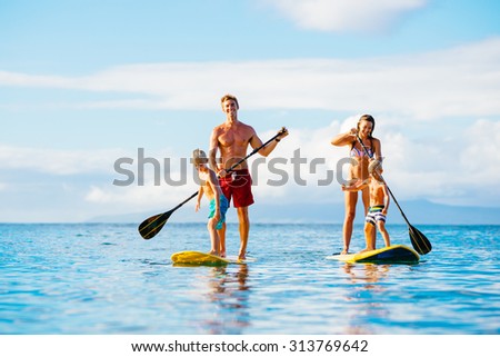 Family Having Fun Stand Up Paddling Together in the Ocean on Beautiful Sunny Morning