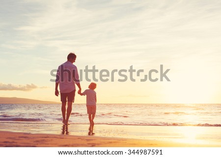 Father and Son Walking Together on the Beach at Sunset. Fatherhood Family Concept
