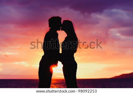 Silhouette of Young Romantic Couple Kissing at Sunset
