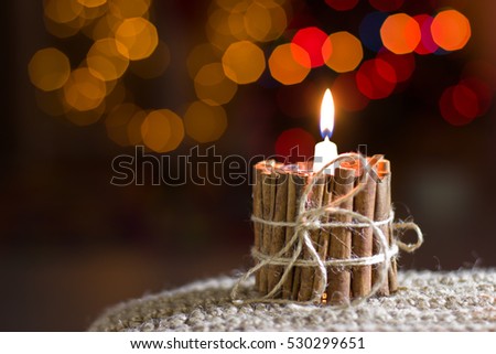 Handmade Candle. Christmas decorations. Candle of cinnamon and bow made of jute. Bokeh.