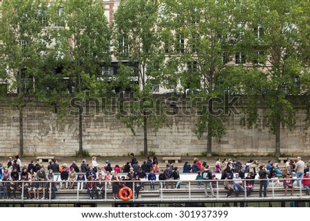 Paris, France - May 15, 2015: A crowd of people takes a boat ride on the river Seine, in Paris, France.