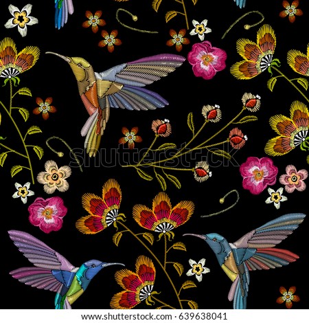 Humming bird and tropical flowers embroidery seamless pattern. Beautiful hummingbirds and exotic flowers embroidery on black background. Template for clothes, textiles, t-shirt design