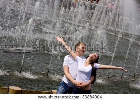 Young happy married couple walk on a summer garden
