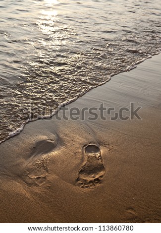 Footsteps in sand at sundown