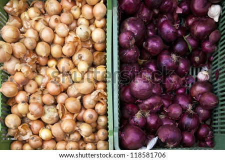 Red and white onions in basket on market