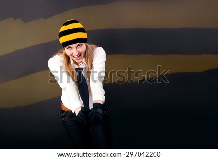 Beautiful and happy blonde yells something in a cap and holding tie