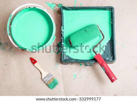 a bucket of paint and a brush roller paint tray