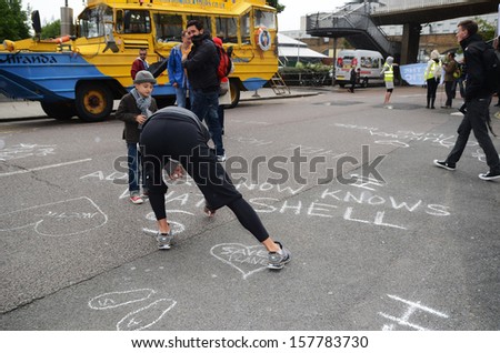 London - September 15: As part of the Aurora the Polar bear march campaigners peacefully protest by putting chalk messages outside the Shell building, London September 15th, 2013 in London England.