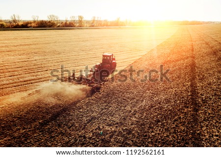 Agriculture machine harvesting crop in fields. Tractor pulls a mechanism for haymaking. Harvesting in autumn in the morning at dawn. agribusiness in the Altai region Russia.