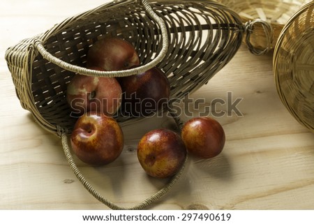 Fall over basket of plums and peaches