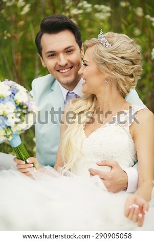 Very beautiful bride and groom embracing in a field where many colors and beautiful nature