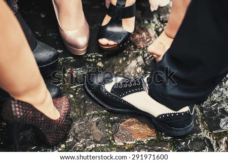 One male black and white shoes among many women