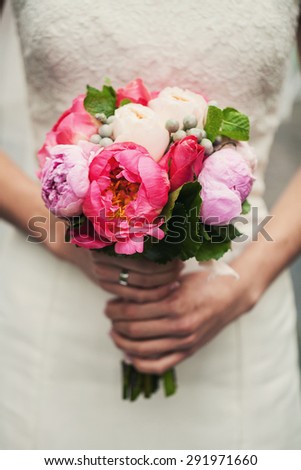 Cute bride in a white dress holding a wedding bouquet before