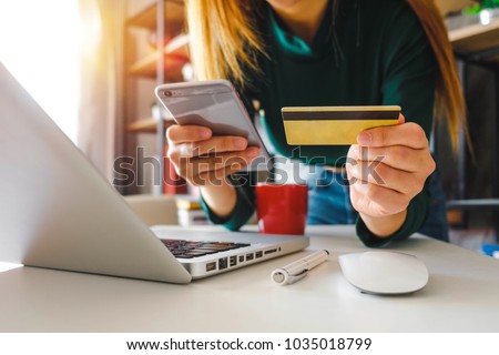 Business man hands using laptop and holding credit card and smart phone with digital layer effect diagram as Online shopping concept