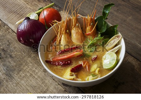 Tom Yum Goong is the most famous of all Thai soups,Tom Yum Soup and Ingredients on old wood.