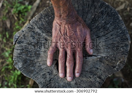 The old man\'s hand on the wooden floor.