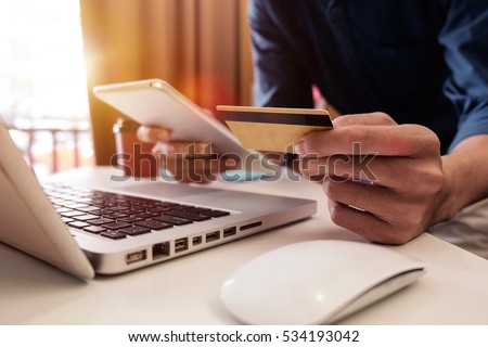 Man hands using laptop and holding credit card with social media as Online shopping concept in morning light