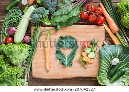 I love healthy food. Concept written with mix of vegetables on wooden background.
