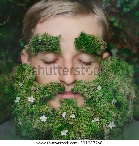 Sleeping hipster lying on grass with beard made of moss and flowers. Taking a nap in a fairytale old forest like a leprechaun, or dwarf concept