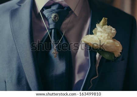 White  rose in a groom suit and cravat,